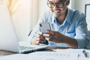 Man at desk with mobile phone