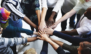 Diverse group putting hands together